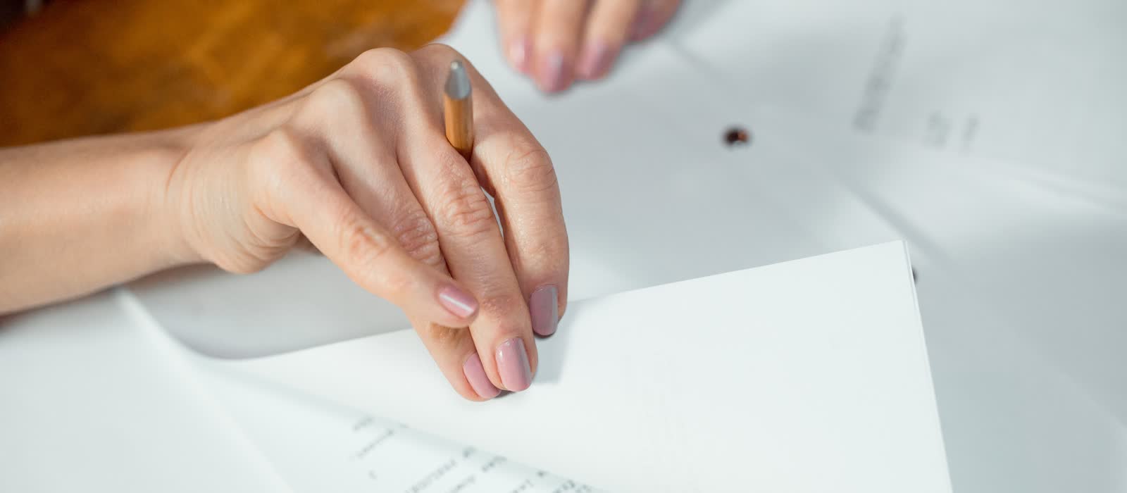 A hand turning a page of a marked-up printed document.